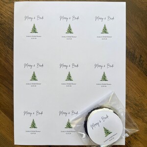 May include: A white sheet of paper featuring nine circular stickers with a watercolor green pine tree illustration, the text Merry & Bride, and the custom text Jessica's Bridal Shower 12.20.26. One sticker is placed inside a clear plastic bag.
