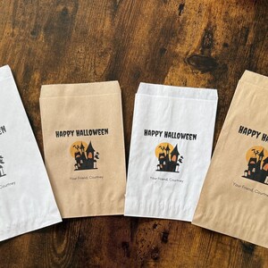 May include: Four paper treat bags with a Halloween theme. Each bag has the words "Happy Halloween" above a graphic of a haunted house and a full moon. The text "Your Friend, Courtney" is below the graphic.