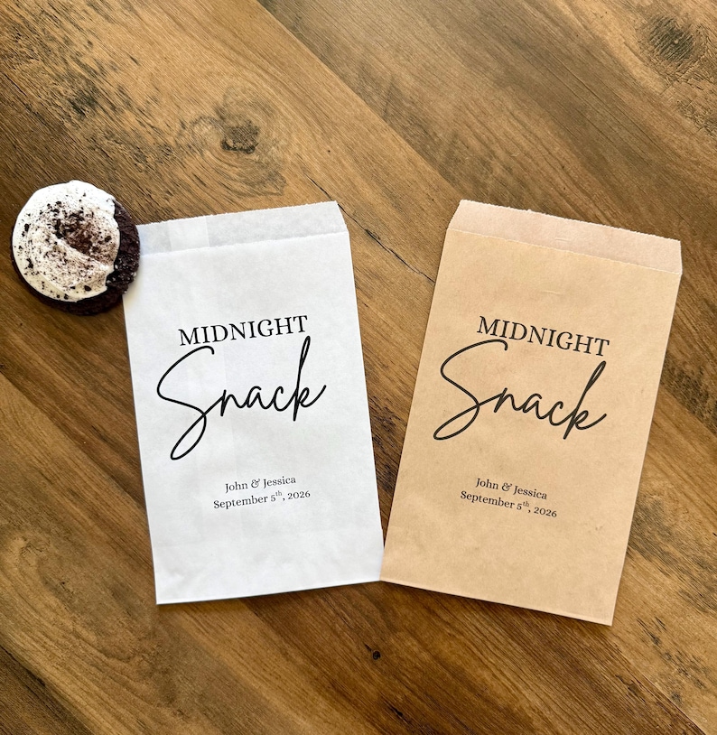 May include: Two rectangular paper bags, one white and one light brown, each printed with the black text Midnight Snack, John & Jessica, and September 5th, 2026. A single dark chocolate cookie with white frosting sits beside the white paper bag.