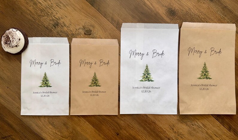 May include: Four rectangular paper favor bags in white and kraft brown colors, each featuring a printed green Christmas tree, the text Merry & Bride, Jessica's Bridal Shower, and the date 12.20.26, accompanied by a small round chocolate treat.