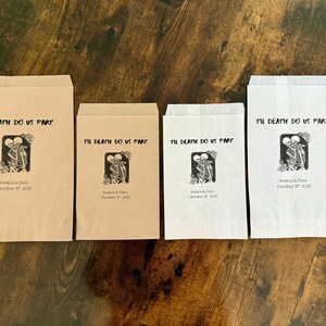 May include: Four paper favor bags with the text "Til Death Do Us Part" and a skeleton couple graphic. The bags are in shades of brown and white, with a decorative closure on two of them. The date "October 31, 2025" is printed below.