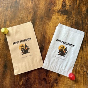 May include: Two Halloween-themed gift bags, one tan and one white, with a spooky castle design and the words "Happy Halloween." The bags also include the text "Your Friend, Courtney."