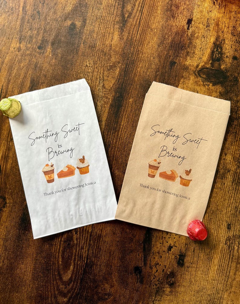May include: Two paper treat bags, one white and one brown, with the text "Something Sweet is Brewing". Each bag features illustrations of coffee, pie, and cupcakes. The text "Thank you for showering Jessica" is printed below.