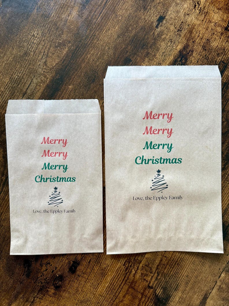 May include: Two brown paper gift bags with the words "Merry Christmas" printed in red and green. A small Christmas tree graphic is below the text, and the words "Love, the Eppley Family" are printed below the tree.