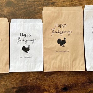May include: Thanksgiving-themed paper bags in various sizes, with the text "Happy Thanksgiving!" and a turkey silhouette. The bags are in brown and white, with a pumpkin and a gourd on a wooden surface.