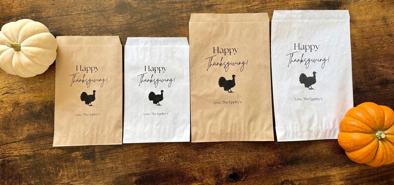 May include: Thanksgiving-themed paper bags in various sizes, with the text "Happy Thanksgiving!" and a turkey silhouette. The bags are in brown and white, with a pumpkin and a gourd on a wooden surface.