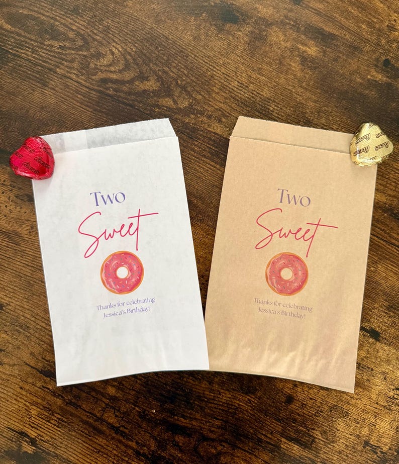 May include: Two paper treat bags, one white and one tan, with a pink donut graphic and the words "Two Sweet". Text at the bottom reads "Thanks for celebrating Jessica's Birthday!". A red heart-shaped candy and a gold heart-shaped candy are on the bags.