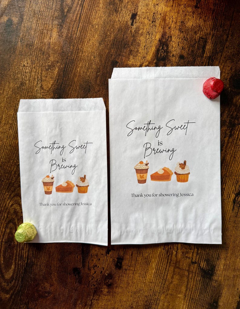 May include: Two white paper treat bags with the text "Something Sweet is Brewing" and illustrations of coffee, pie, and cupcakes. The text "Thank you for showering Jessica" is below the illustrations.