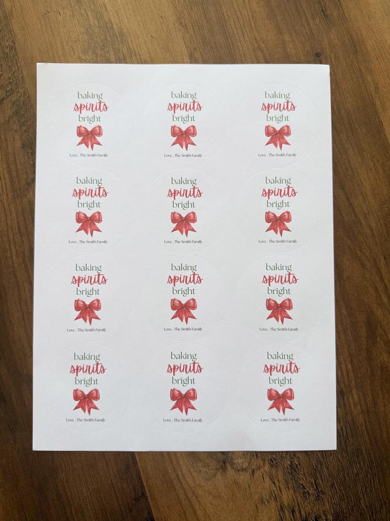 May include: A sheet of twelve circular white stickers, each featuring a red bow illustration, the text 'baking spirits bright' in dark gray and red, and the personalized text 'Love, The Smith Family' at the bottom of each label.