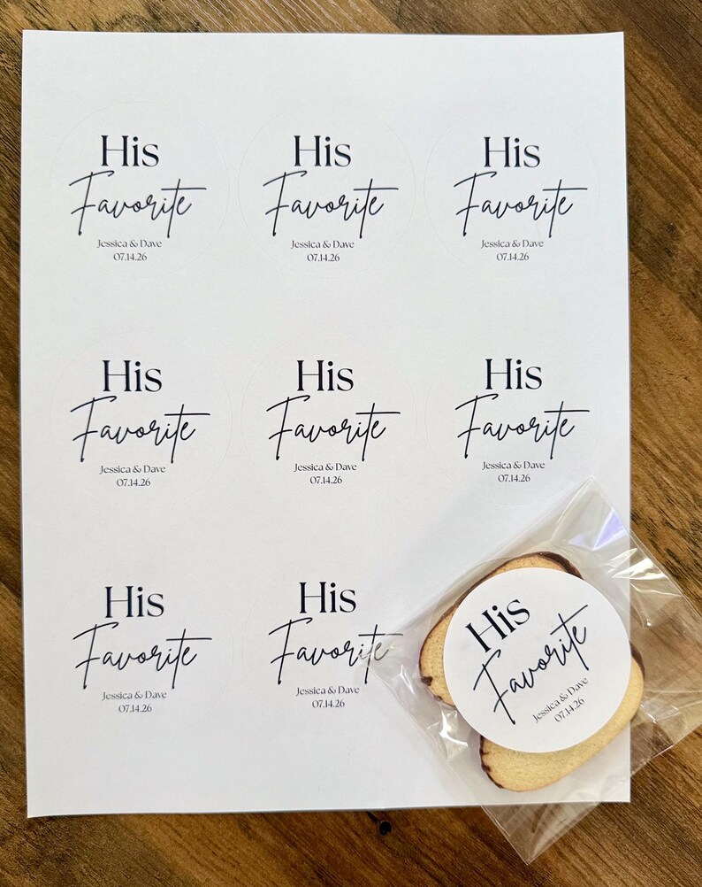 Peut inclure: Une feuille blanche pr&eacute;sentant neuf &eacute;tiquettes adh&eacute;sives circulaires avec le texte noir His Favorite, Jessica & Dave, et 07.14.26. Une &eacute;tiquette identique est appos&eacute;e sur un petit biscuit rond clair dans un sachet en plastique transparent.