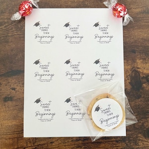 K&ouml;nnte beinhalten: Ein Bogen wei&szlig;er Aufkleber mit dem Text "Sweet Endings to New Beginnings" und einer Abschlusskappe. Ein Schokoladen-Chip-Keks in einer durchsichtigen T&uuml;te und zwei rot folienverpackte S&uuml;&szlig;igkeiten sind ebenfalls vorhanden. Der Text "Congratulations Cooper Class of 2026" ist ebenfalls auf den Aufklebern.