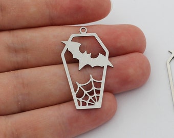 May include: Two silver metal charms shaped like a coffin with a bat and spider web design.