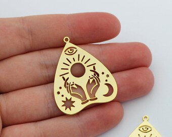 May include: Two gold-coloured metal charms shaped like a heart with a pointed top. The charms feature a sun, moon, stars, and two hands reaching up towards the sun. The charms have a hole at the top for attaching to a necklace or bracelet.