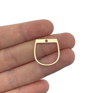 May include: Gold-toned metal charm shaped like a horseshoe with a small hole at the top.