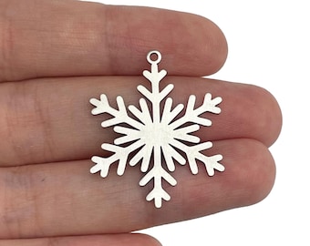 May include: A silver snowflake charm with a loop at the top for hanging. The snowflake is detailed and intricate.