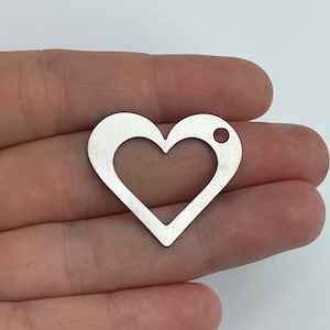 May include: Silver metal heart charm with a hole at the top. The heart is hollow and has a smooth, polished finish.