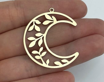 May include: Gold metal crescent moon charm with a delicate leafy design. The charm has a hole at the top for attaching to jewelry.