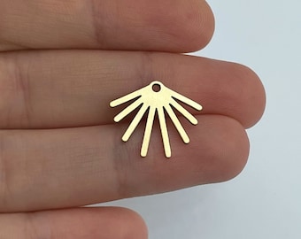 May include: Gold metal charm with a sunburst design. The charm has a small hole at the top for attaching to jewelry.