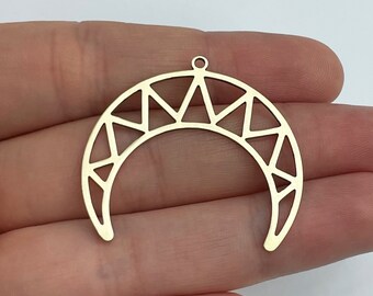 May include: A gold-colored crescent moon pendant with a geometric design. The pendant features a series of triangles along the top and a small loop for hanging. The openwork design allows light to pass through, creating a delicate and airy feel.