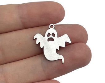 Pode incluir: Encanto de metal prateado em forma de fantasma com uma cara carrancuda. O fantasma tem asas e uma cauda que flui.