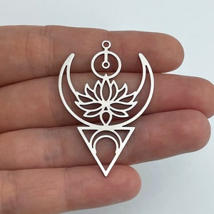 May include: Silver pendant with a geometric design featuring a lotus flower, crescent moons, and a triangle.