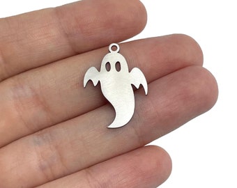 Pode incluir: Encanto de fantasma de metal prateado com um laço na parte superior para pendurar. O fantasma tem um design simples e de desenho animado com dois olhos e um corpo arredondado.