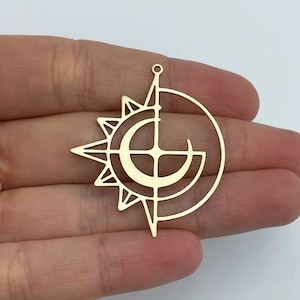 May include: Gold metal charm featuring a sun and moon design. The sun is a stylized starburst with a circle in the center. The moon is a crescent shape with a circle in the center. The sun and moon are overlapping.