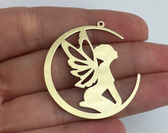 May include: Gold metal charm featuring a fairy silhouette with wings inside a crescent moon shape.