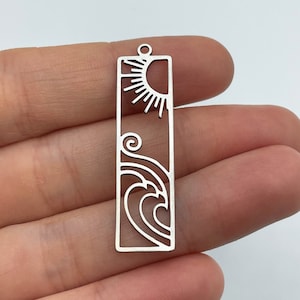 May include: Silver charm with a sun and wave design. The charm is rectangular and has a hole at the top for attaching to a bracelet or necklace.
