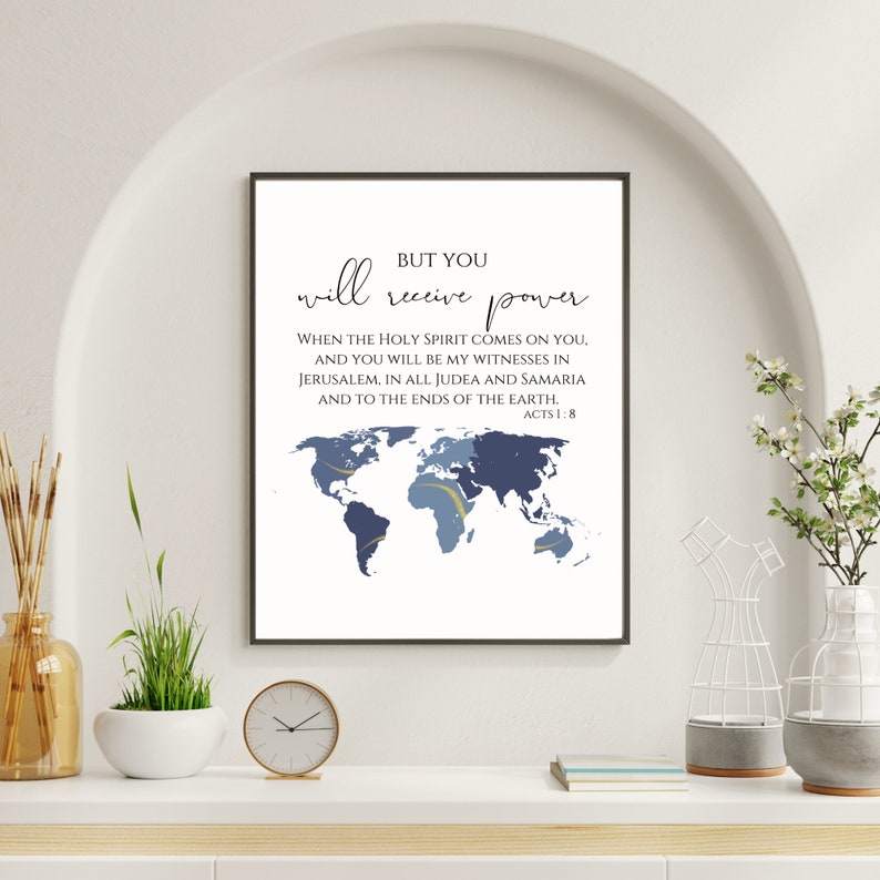 May include: A white framed print with a blue and gold world map and the text "BUT YOU will receive power WHEN THE HOLY SPIRIT COMES ON YOU, AND YOU WILL BE MY WITNESSES IN JERUSALEM, IN ALL JUDEA AND SAMARIA AND TO THE ENDS OF THE EARTH. ACTS 1:8"