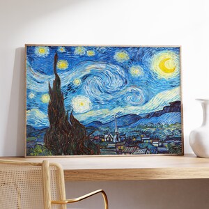 May include: A framed painting of a starry night sky with a crescent moon and a village in the distance. The sky is painted in shades of blue and yellow, with swirling brushstrokes. The village is painted in shades of brown and green.
