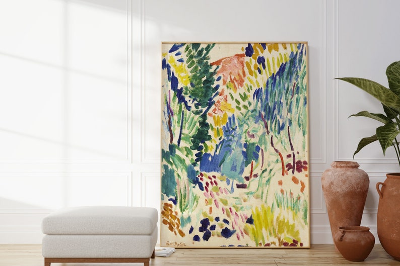 May include: Abstract painting of a landscape with vibrant colours, including green, blue, yellow, and pink. The painting is framed and hanging on a white wall.