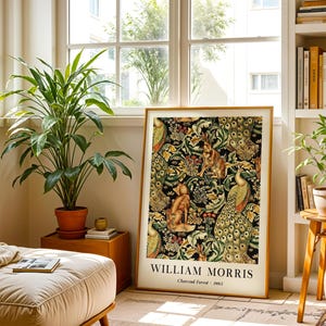 Peut inclure: Une impression d'art encadr&eacute;e rectangulaire pr&eacute;sentant le motif William Morris Charcoal Forest 1885. L'image affiche un motif dense de paons, de lapins et de renards au milieu d'un feuillage vert complexe et de motifs floraux sur fond noir.