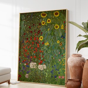 May include: A painting of a field of flowers with sunflowers in the background. The flowers are in shades of red, pink, white, blue, and yellow. The sunflowers are in shades of yellow and green. The painting is framed in gold.