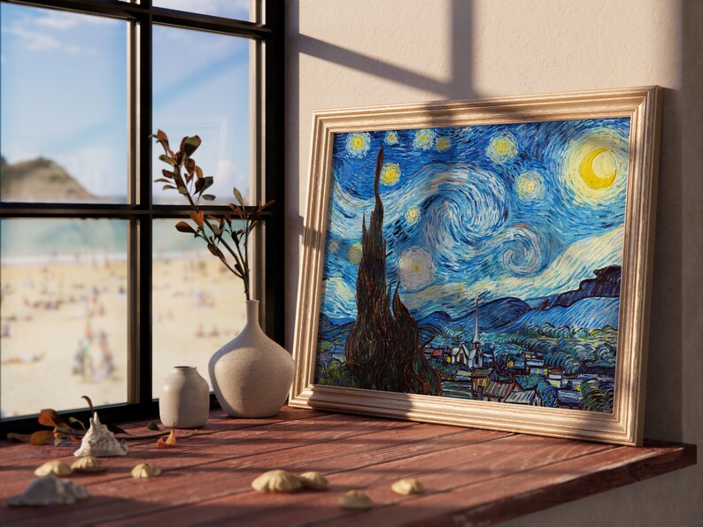 May include: A framed print of Vincent van Gogh's "Starry Night" painting, featuring a swirling blue sky with yellow stars and a crescent moon. The print is displayed on a wooden surface with a vase and a small plant.