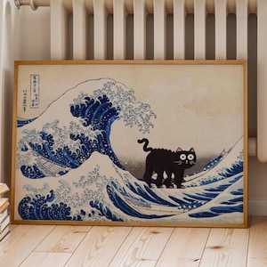 May include: A framed print depicting a black cat on a wave, a parody of Hokusai's "The Great Wave off Kanagawa." The image shows a black cat with large eyes set against blue and white waves, framed in light wood, a humorous take on the classic.