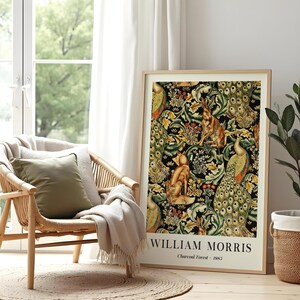 Peut inclure: Une impression d'art encadr&eacute;e pr&eacute;sentant le motif Charcoal Forest 1883 de William Morris avec un fond noir, un feuillage vert complexe et des illustrations d'un renard, de lapins et de paons. Le texte William Morris Charcoal Forest 1883 est imprim&eacute;.