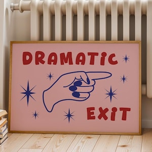 Puede incluir: Un estampado rosa enmarcado con las palabras "DRAMATIC EXIT" en rojo, con una mano azul que apunta hacia la derecha. Estallidos de estrellas azules rodean el texto y la mano. El marco es de color marrón claro.