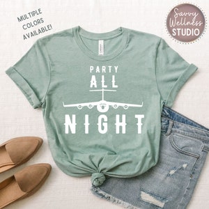 May include: A light green t-shirt with the text "Party All Night" in white. A white silhouette of an airplane is above the text.