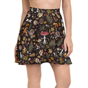 May include: A black skater skirt with a colorful print of mushrooms, leaves, and other forest elements.