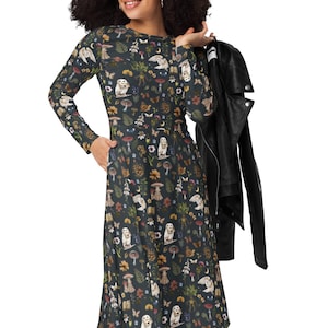 May include: A long-sleeved, dark blue dress with a whimsical pattern of mushrooms, ghosts, and other forest elements. The dress is paired with black boots and a black leather jacket.