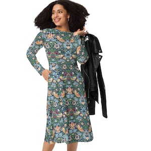 May include: A long-sleeved dress with a floral print featuring birds and flowers. The dress is blue, green, and orange. The model is wearing black boots.