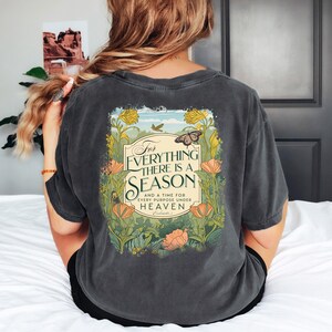 May include: A dark gray t-shirt with a floral design and the text "For everything there is a season and a time for every purpose under heaven."  The text is in a vintage style font.