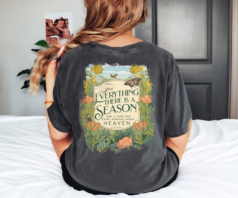May include: A dark gray t-shirt with a floral design and the text "For everything there is a season and a time for every purpose under heaven."  The text is in a vintage style font.