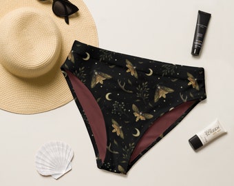Op de afbeelding: Zwarte, hoge taille bikini broek met een donker bloemenprint met motten, halve manen en botanische elementen. De voering is bordeauxrood.