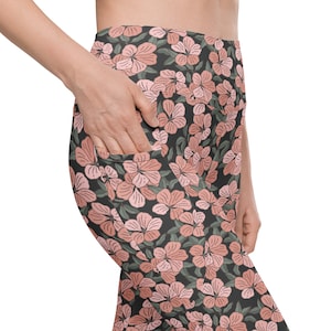 May include: Black leggings with a pink floral print. The leggings have side pockets.