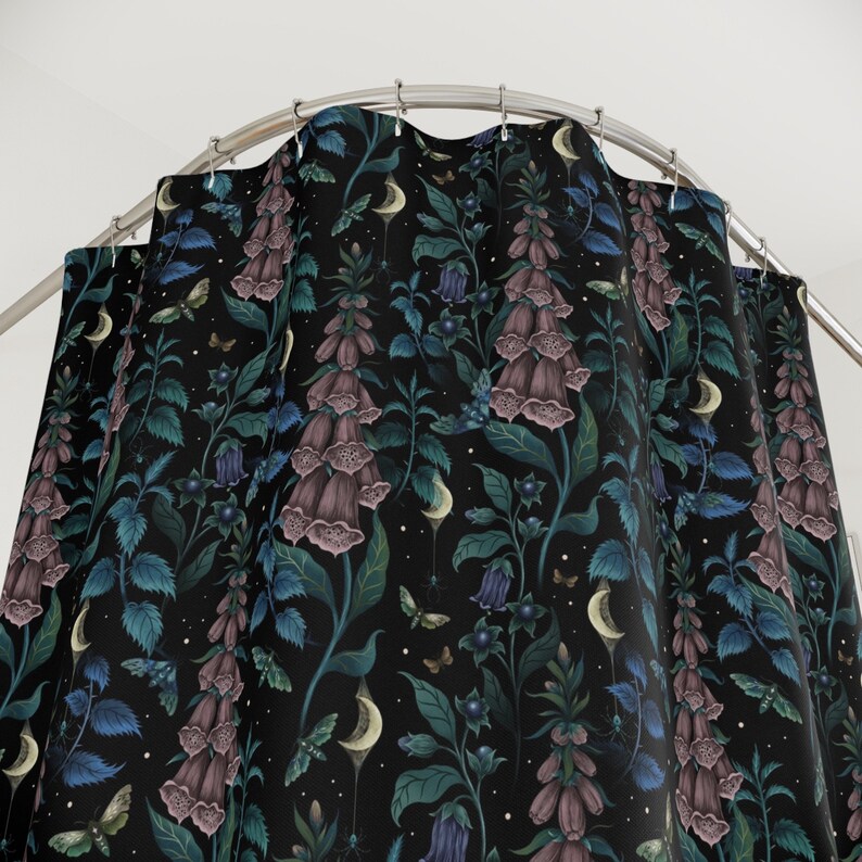 May include: A black shower curtain with a repeating pattern of purple foxglove flowers, green leaves, and white crescent moons. The background is a dark navy blue.