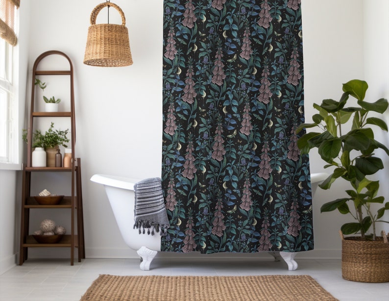May include: A black shower curtain with a floral pattern featuring pink and blue flowers, green leaves, and crescent moons. The shower curtain is hanging in a bathroom with a white bathtub and a wooden ladder shelf.