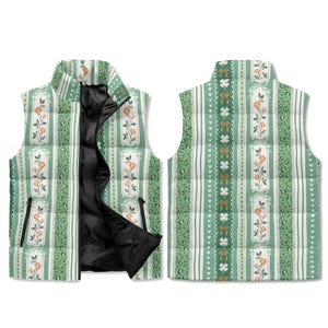 Könnte beinhalten: Eine wendbare Steppweste mit floralem und gestreiftem Muster. Die Vorderseite hat ein grün-weiß gestreiftes Design mit floralen Akzenten und einem schwarzen Reißverschluss. Die Rückseite hat ein ähnliches Muster mit Schleifen und Kleeblättern. Die Weste ist für jeden geeignet.
