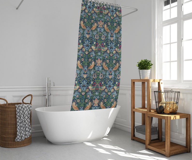 Puede incluir: Una cortina de ducha azul y verde con un patr&oacute;n floral y de p&aacute;jaros. La cortina est&aacute; colgada en un ba&ntilde;o con una ba&ntilde;era blanca y una estanter&iacute;a de madera.